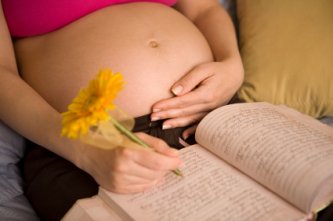 pregnant woman writing her thoughts in her diary
