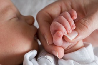 newborn baby grasping mommies hand