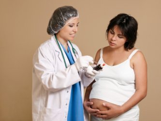 pregnant woman consulting with nurse midwife