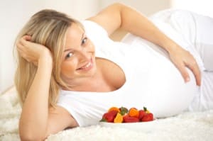 pregnant woman laying down and eating